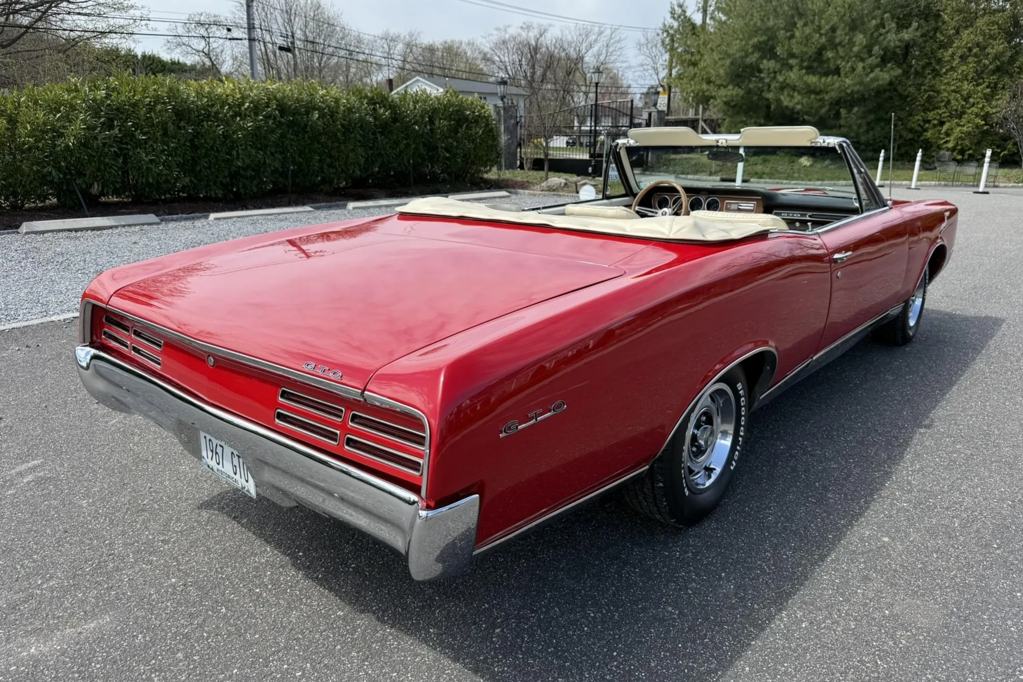Front three-quarter view of a meticulously restored 1967 Pontiac GTO Convertible in Regimental Red