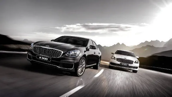 Front three-quarter view of the Kia K900 showcasing its large 'tiger-nose' grille and LED headlights