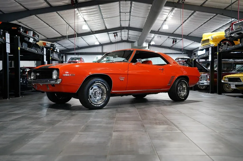 Front view of a vibrant orange 1969 Chevrolet Camaro, highlighting its iconic grille