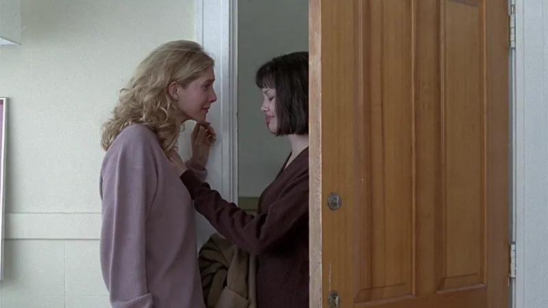 Gia rests her hand on Linda's, a tender gesture laden with unspoken farewells.