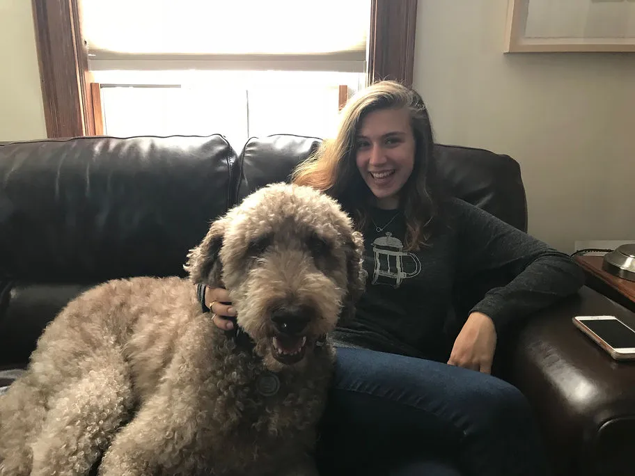 Grace Scott-Hiser cuddling two dogs affectionately