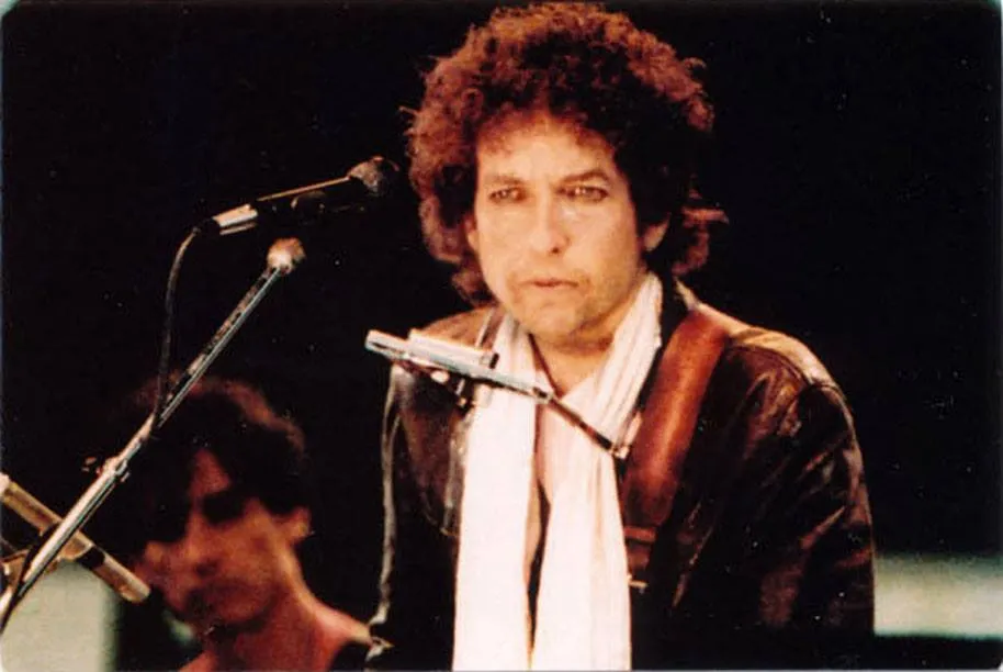 Gregg Sutton sharing a moment on stage with Bob Dylan, capturing the camaraderie within the 1984 touring group