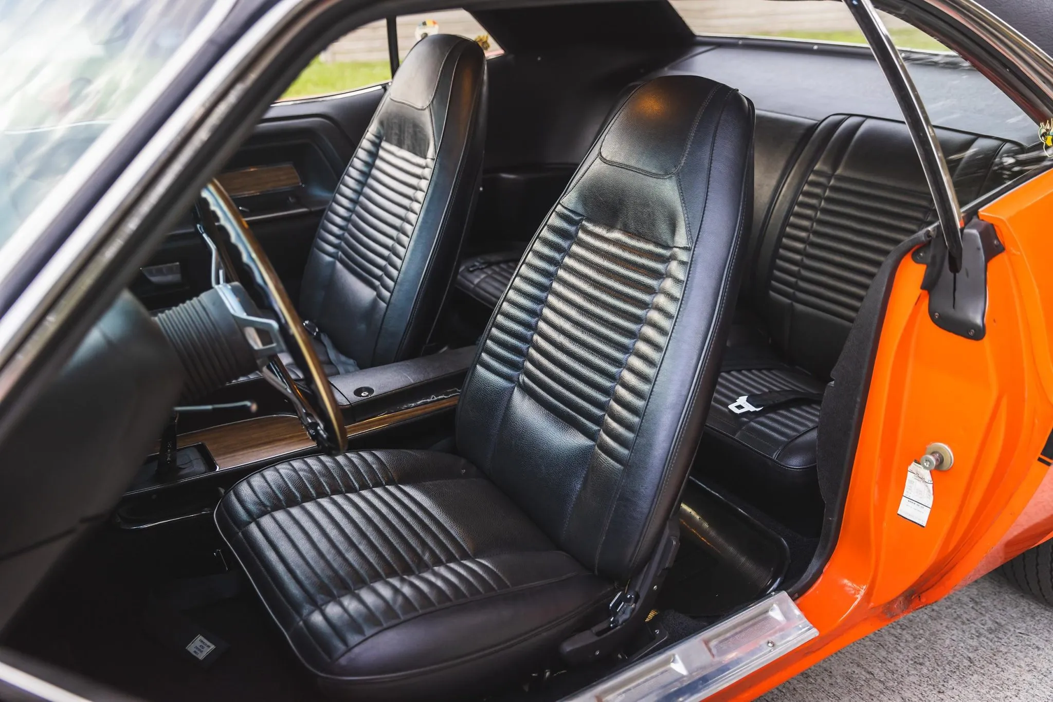 Interior shot of the 1970 Dodge Challenger R/T 426 Hemi, showing black bucket seats and woodgrain console