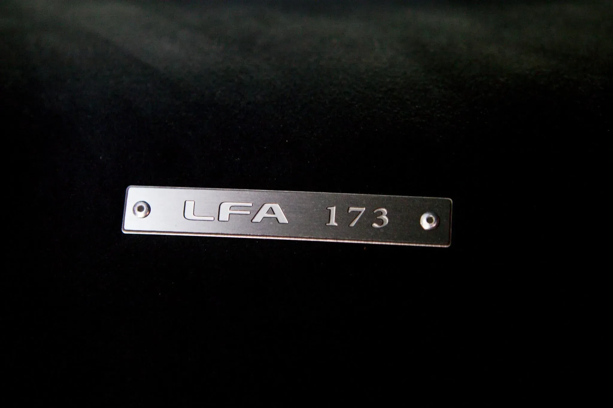 Interior shot of the 2012 Lexus LFA showing black leather seats with red trim and infotainment screen