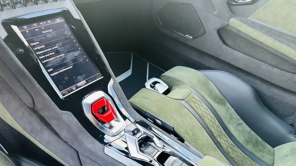 Interior shot of the Lamborghini Huracán Sterrato, focusing on the suede steering wheel and digital instrument cluster.
