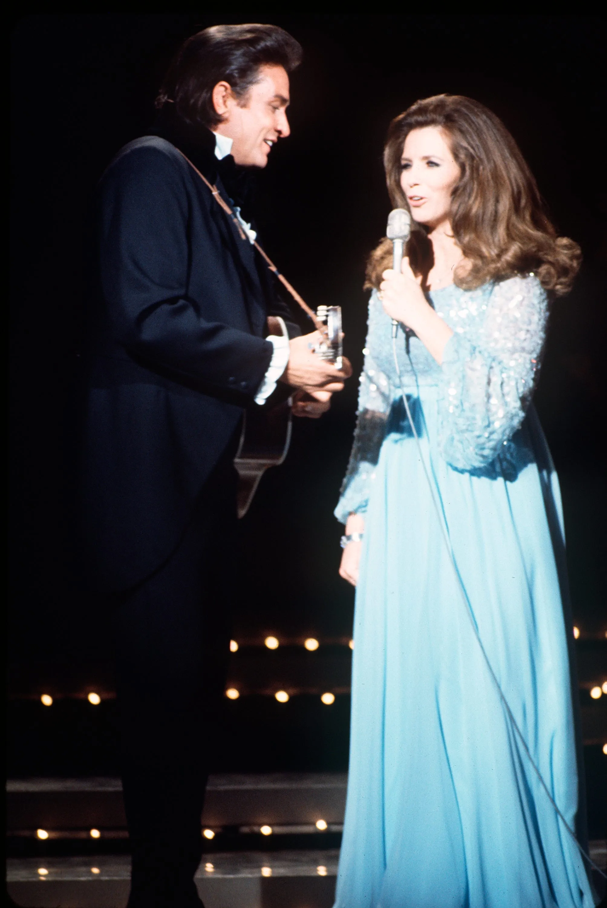 Johnny Cash and June Carter performing together on 'The Johnny Cash Show' stage in 1970