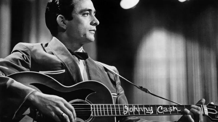 Johnny Cash performing energetically on stage in 1968