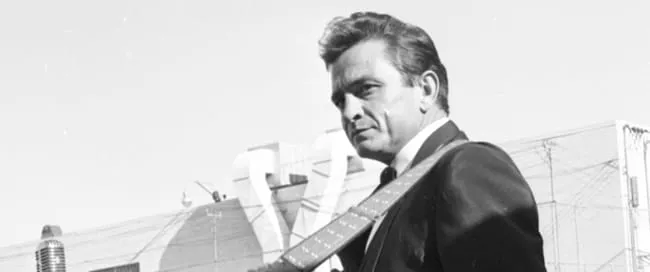 Johnny Cash with a thoughtful expression, looking over his left shoulder.