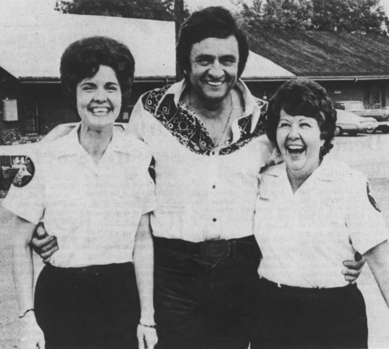 Johnny Cash with Spalding Sheriff's Department secretaries Linda Fields and Rosa Howard in September 1974.