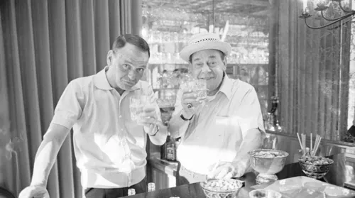 Legendary performers Frank Sinatra and Joe E. Lewis sharing a moment, highlighting their real-life friendship