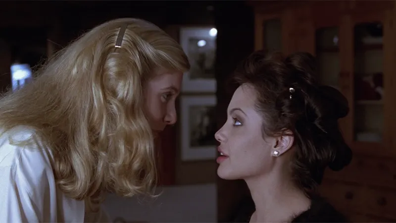Linda leans close to Gia, a moment of undeniable chemistry and shared vulnerability.