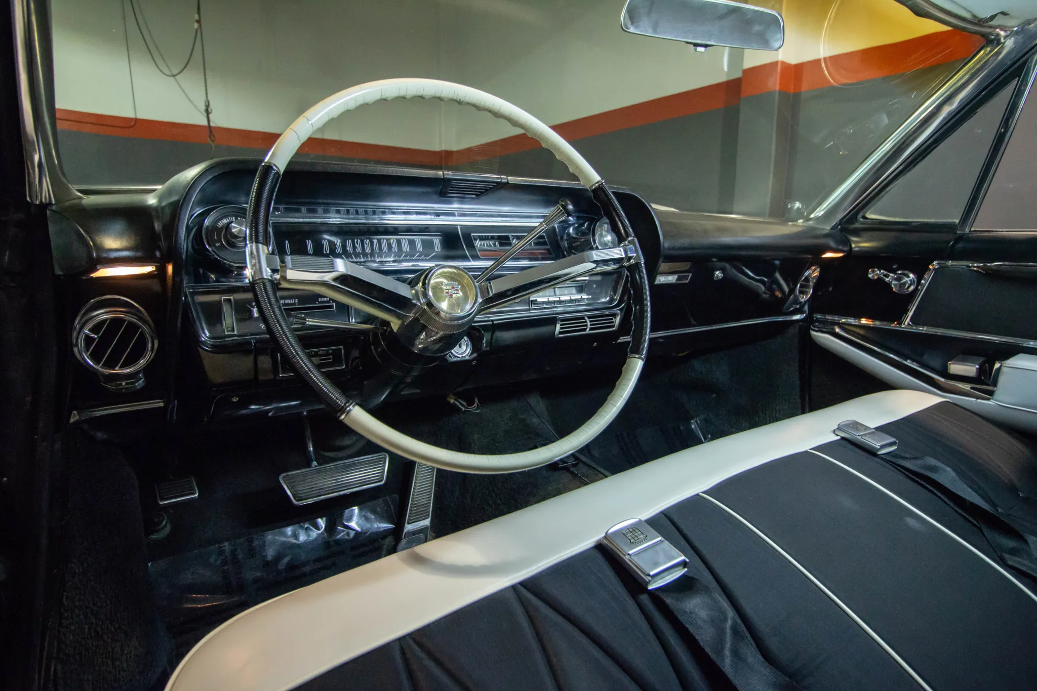 Luxurious black and white vinyl interior of the 1964 Cadillac Coupe DeVille, showing the dashboard