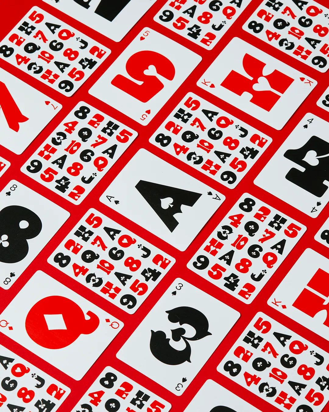 Paula Scher's 'Just Type' playing cards, Edition 2, featuring minimalist mid-century inspired typography and integrated suit symbols.