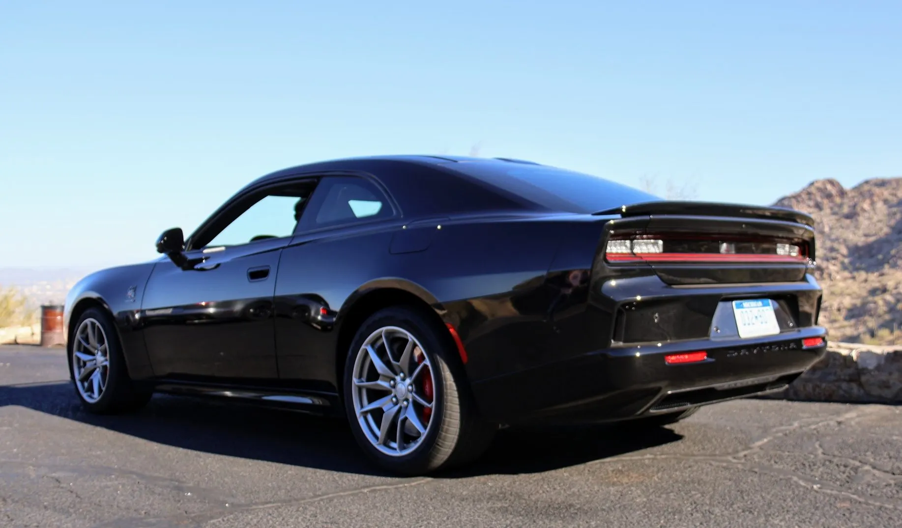 Rear three-quarter view of the 2024 Dodge Charger Daytona, highlighting its wide tires