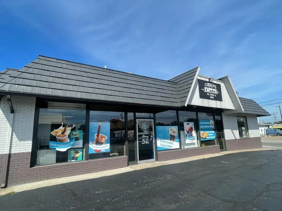 Restaurant building with gray roof and large windows at Carmen's Café