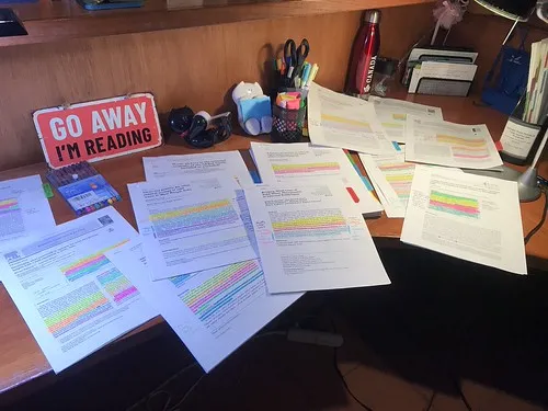 Stack of highlighted research papers ready for analysis