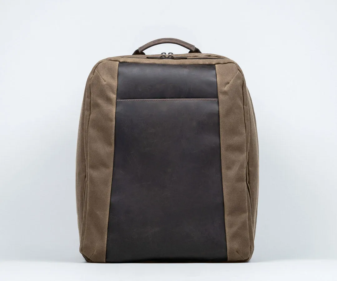 Tech Folio Tank backpack on table with accessories including laptop, controller, and water
