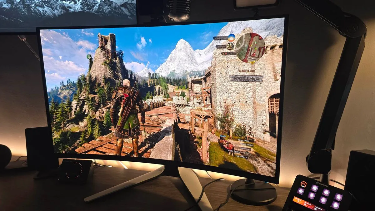 The Alienware AW3225QF QD-OLED monitor prominently featured on a clean desk setup