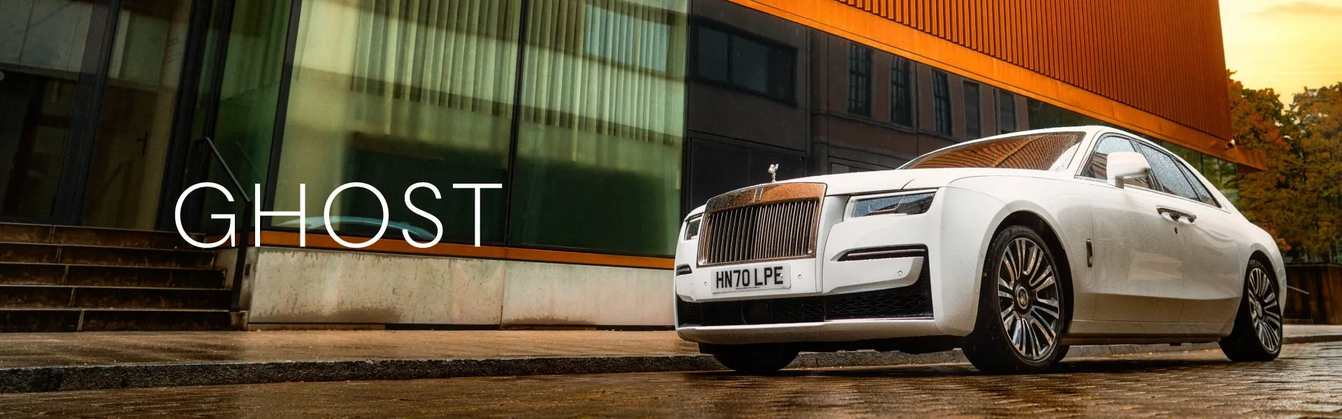 The elegant exterior of a Rolls-Royce Ghost, showcasing its luxurious design and iconic Spirit of Ecstasy emblem.