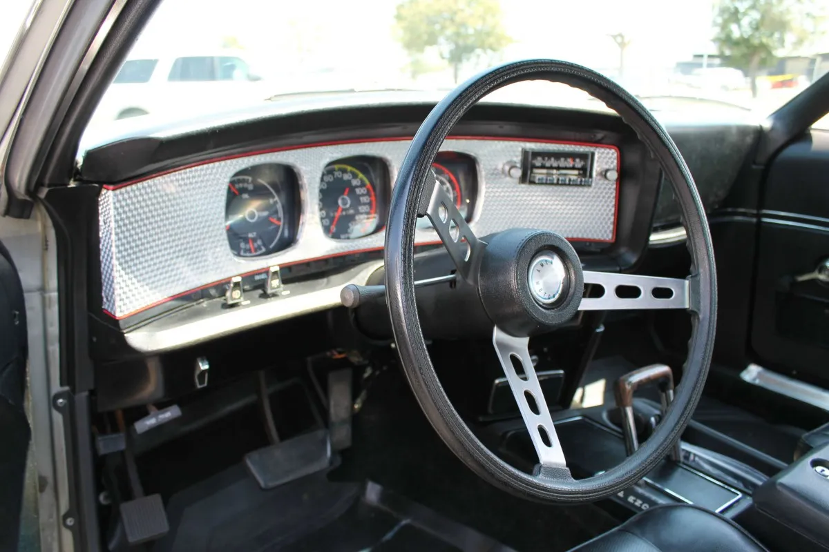 The iconic curved, engine-turned dash panel and black vinyl interior of the 1973 AMC Javelin AMX.