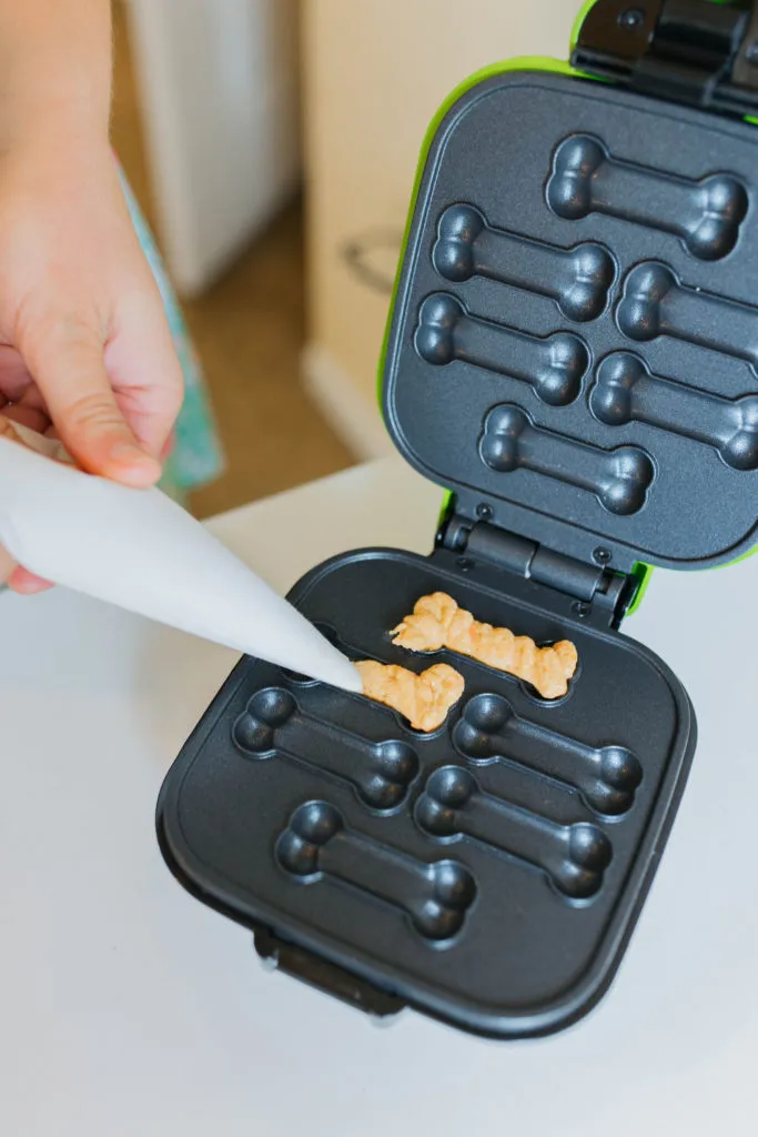 The indicator light on the dog treat maker has turned green, signaling the treats are ready.
