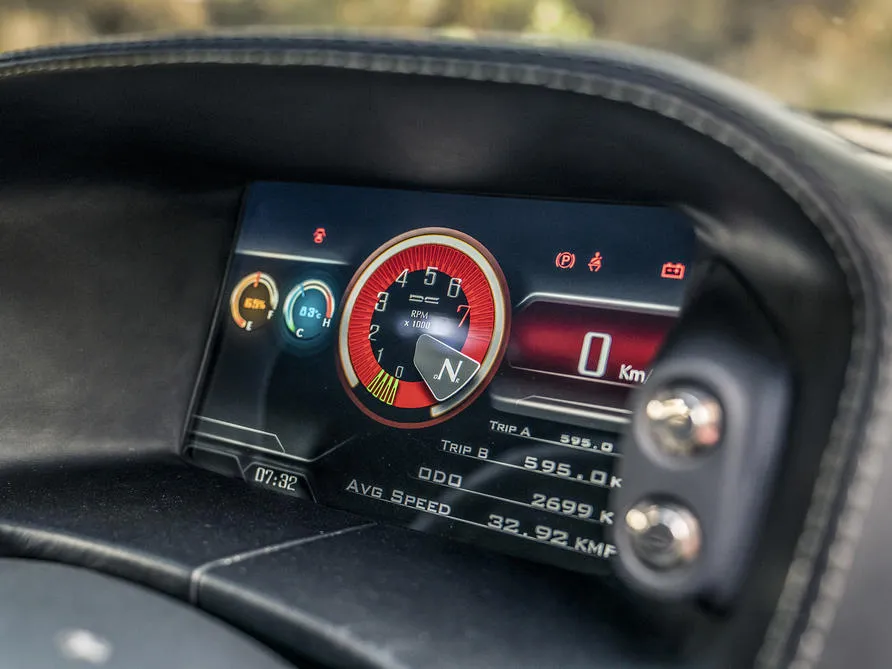 The interior of the DC Avanti, featuring its somewhat retro-styled dashboard, manual gear lever, and bucket seats with red stripe accents.
