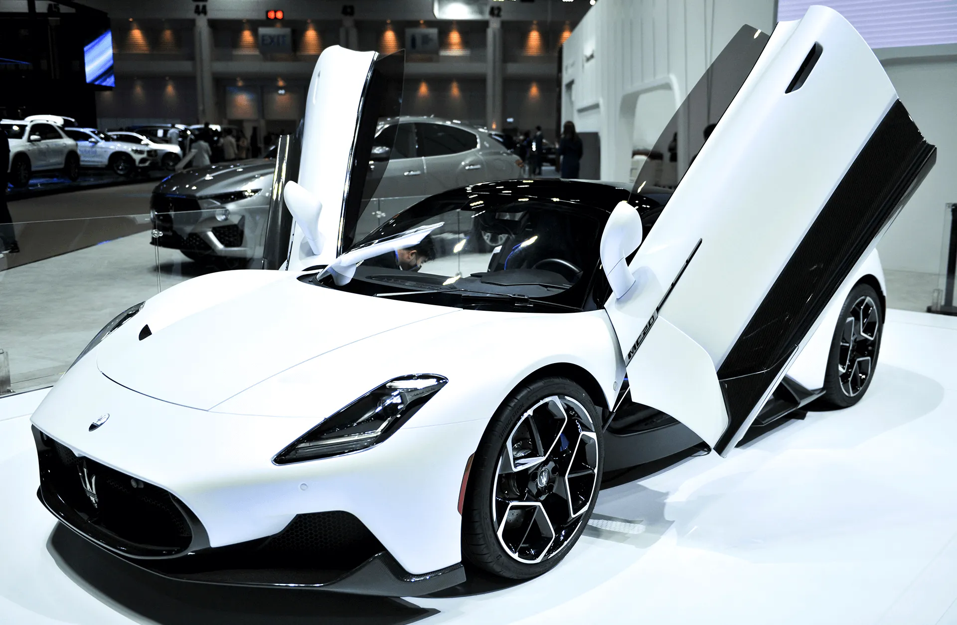 The Maserati MC20 showcased at a motor show, emphasizing its aggressive front fascia