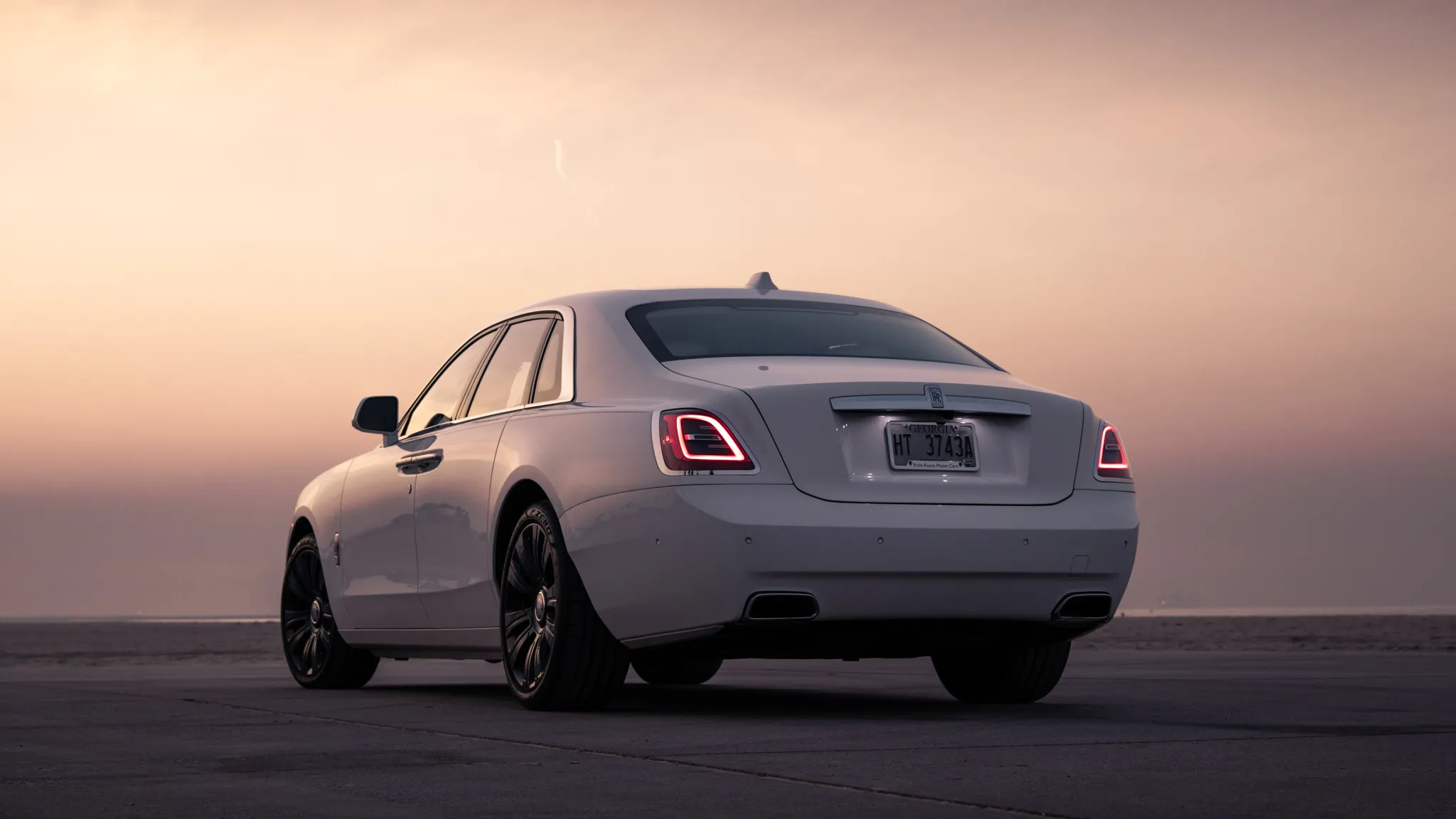 The rear profile of the 2021 Rolls-Royce Ghost, showcasing its elegant lines and commanding presence on the road.