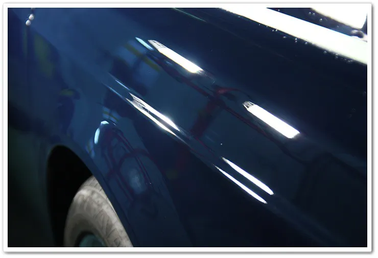 The same Rolls Royce Phantom's rear quarter panel after compounding, showing significantly improved clarity and gloss, with most defects removed.