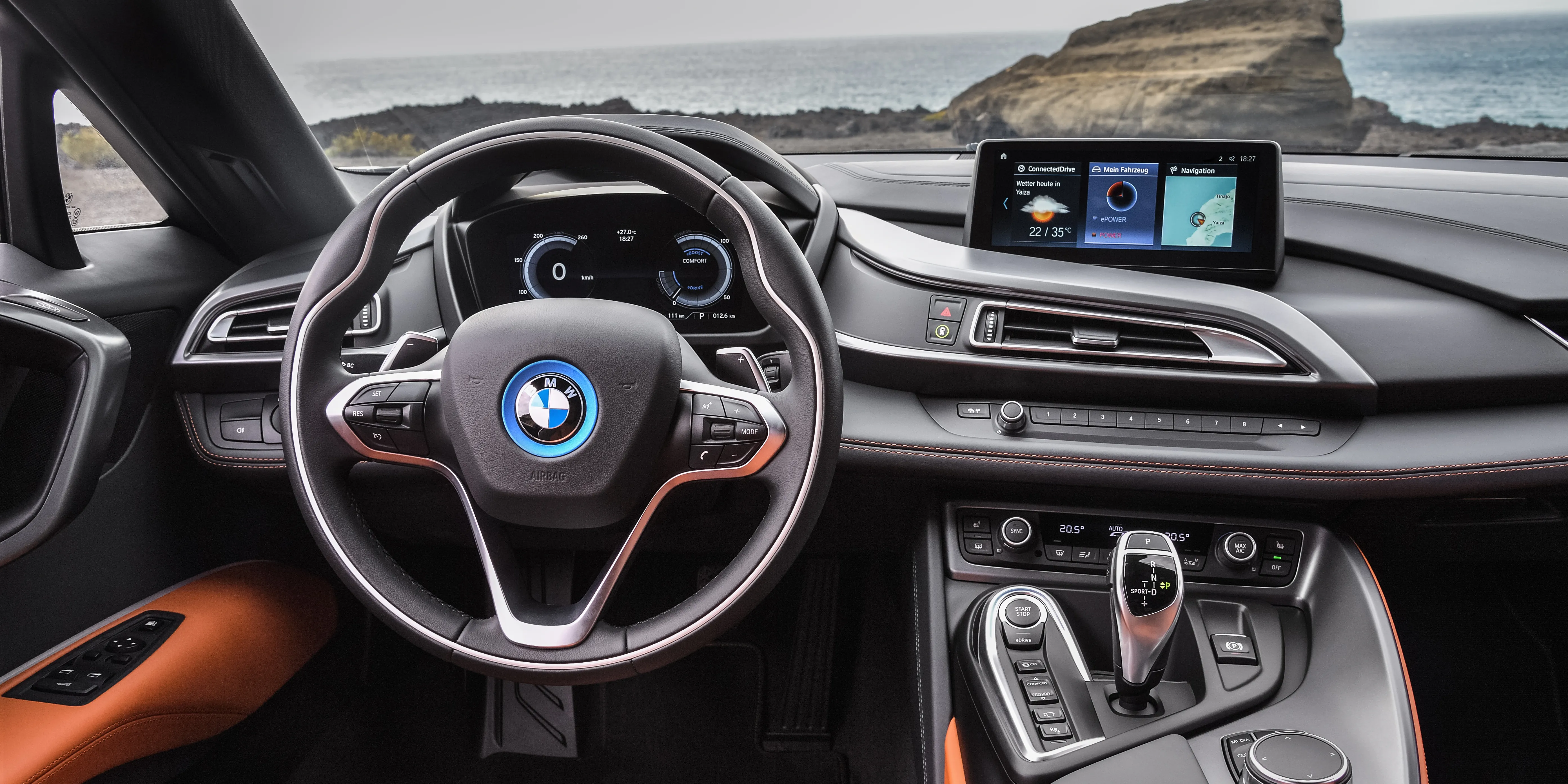 The sleek, aerodynamic rear view of the BMW i8 in motion on a road