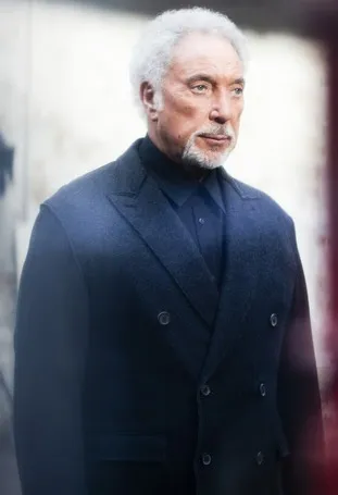 Tom Jones performing live, showcasing his reinvented style with a powerful baritone