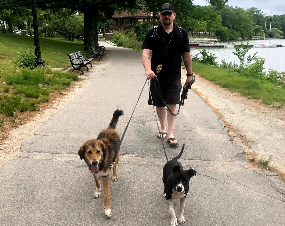 Tom Smith happily walking a dog on a leash outdoors