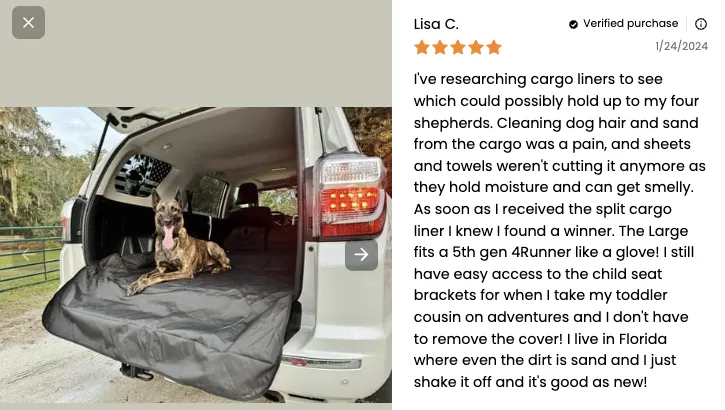 Two German Shepherds comfortably lying on a dark cargo liner in the back of a vehicle, demonstrating a secure fit.