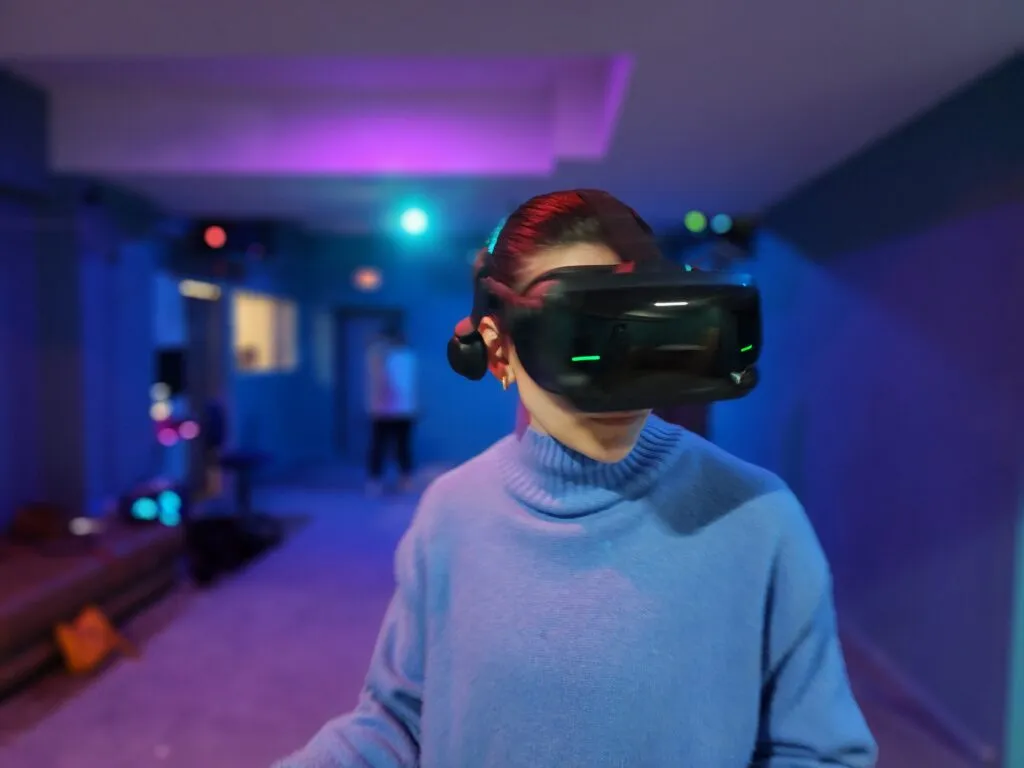 Two individuals engaged in a VR game, one in a seated position and another standing, in a dedicated VR gaming area