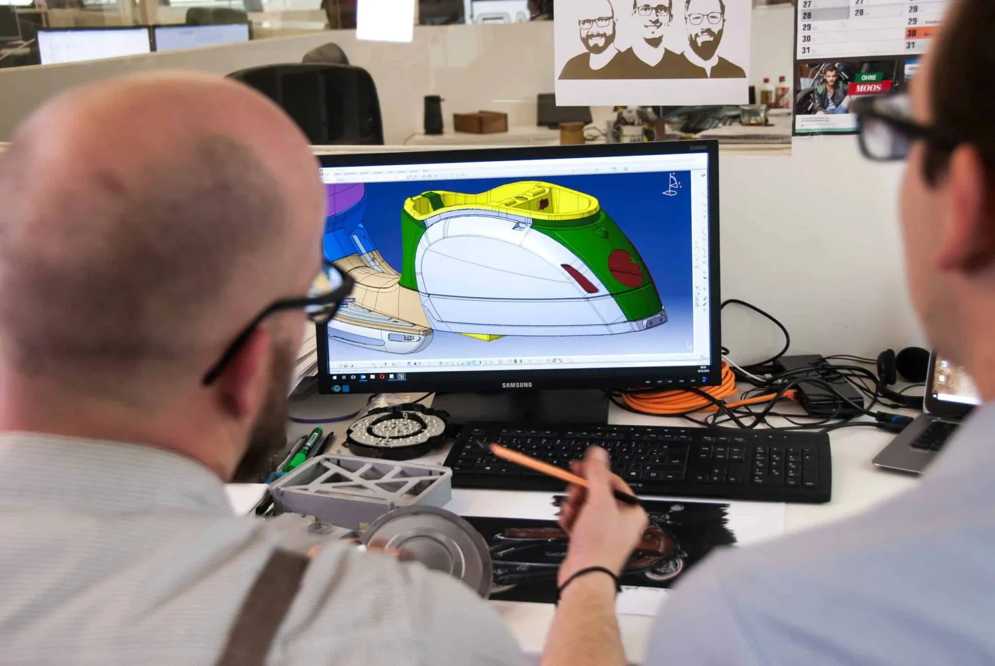 Working on CAD software on computer, displaying detailed 3D models and blueprints