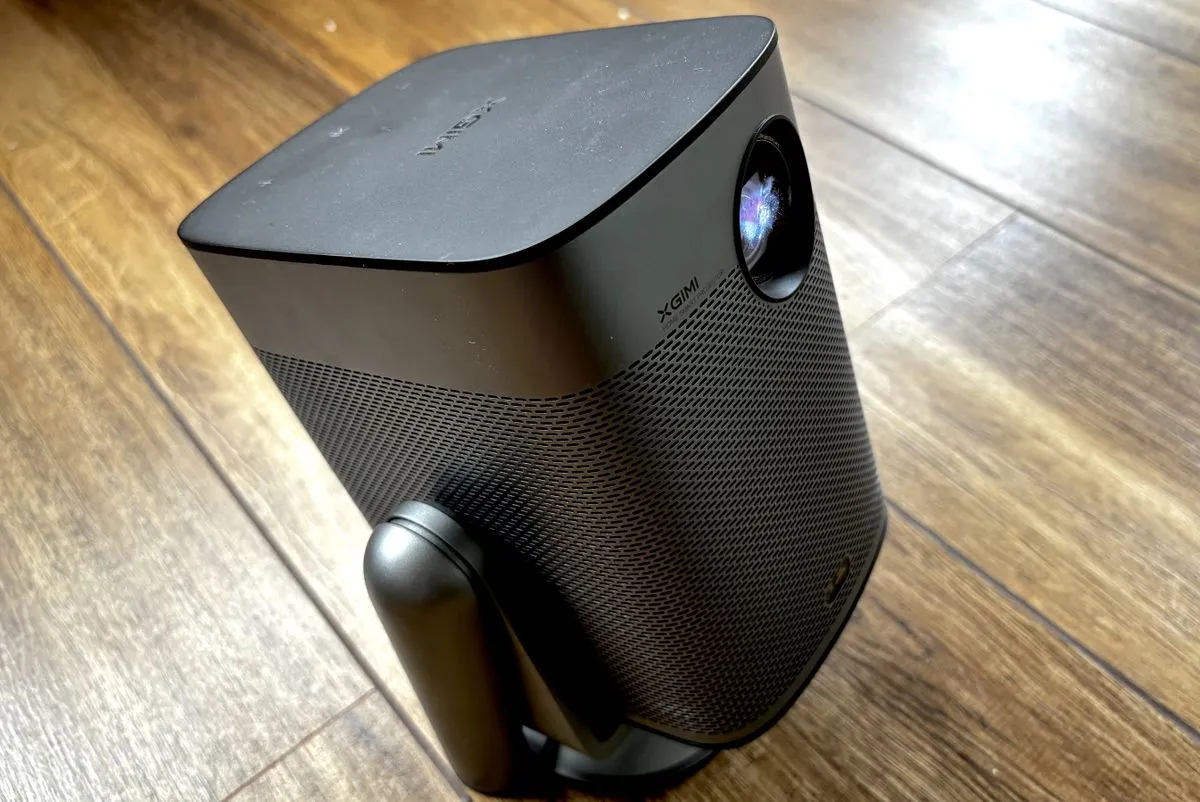Xgimi Halo Plus mini projector in use, projecting onto a wall in a dimly lit room