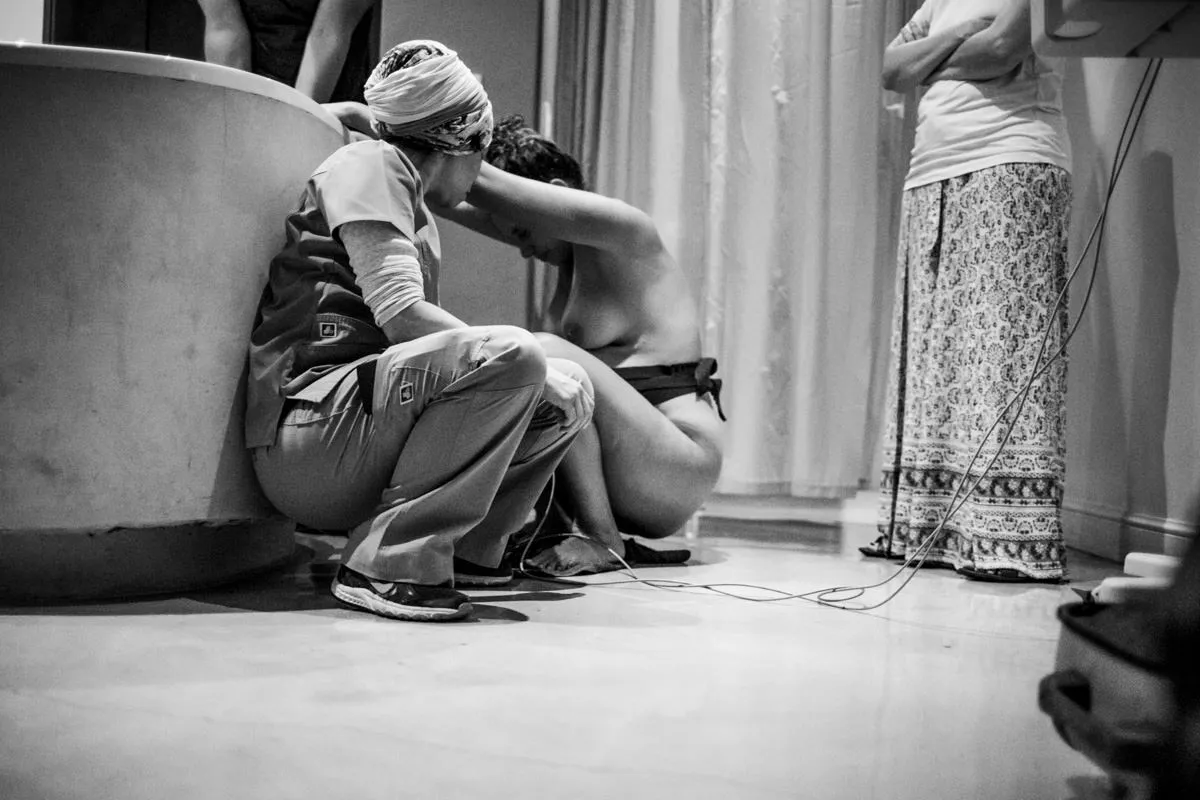 The mother rests, holding her baby close after delivery.