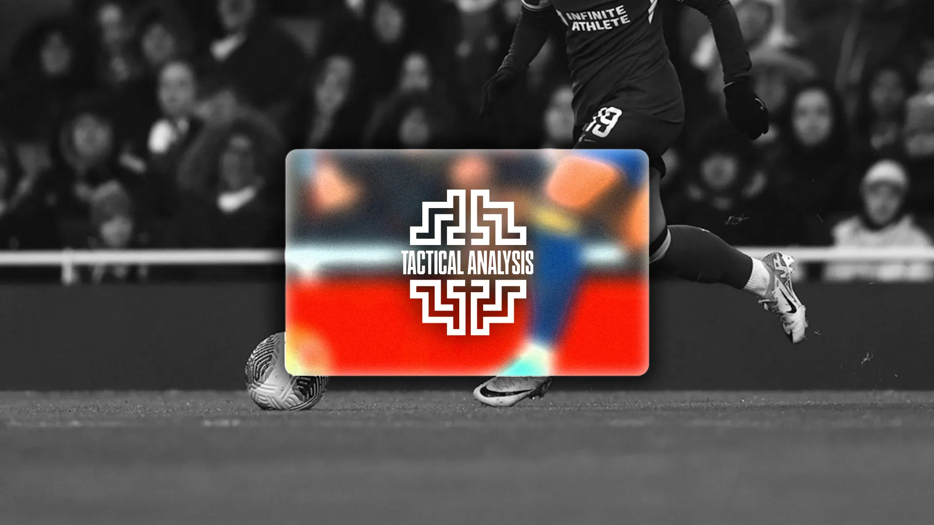A soccer player in a black uniform and a Catapult vest kicking a soccer ball in a stadium setting.
