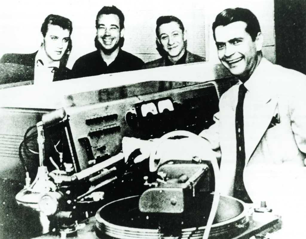 Elvis Presley, Bill Black, and Scotty Moore at Sun Records with owner/producer Sam Phillips.