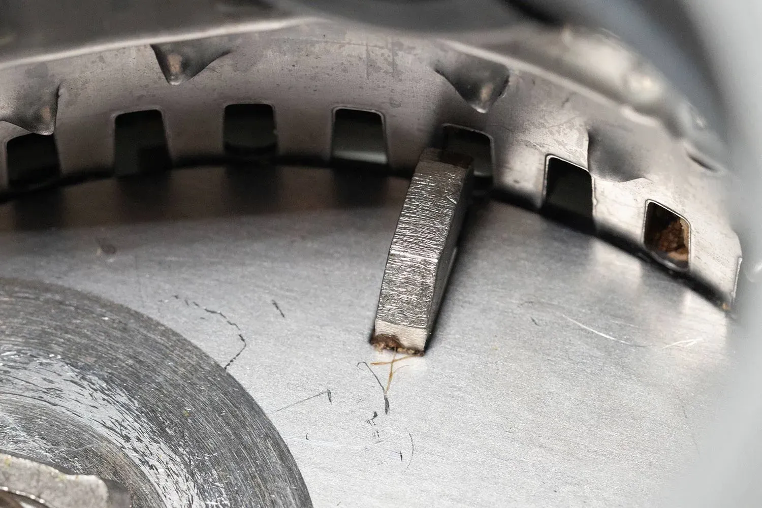Inside view of InSinkErator Evolution 1-hp food waste disposer, highlighting parts of Excel Tri-Action Lug system, partially showing details of grater/grinder ring and flywheel.