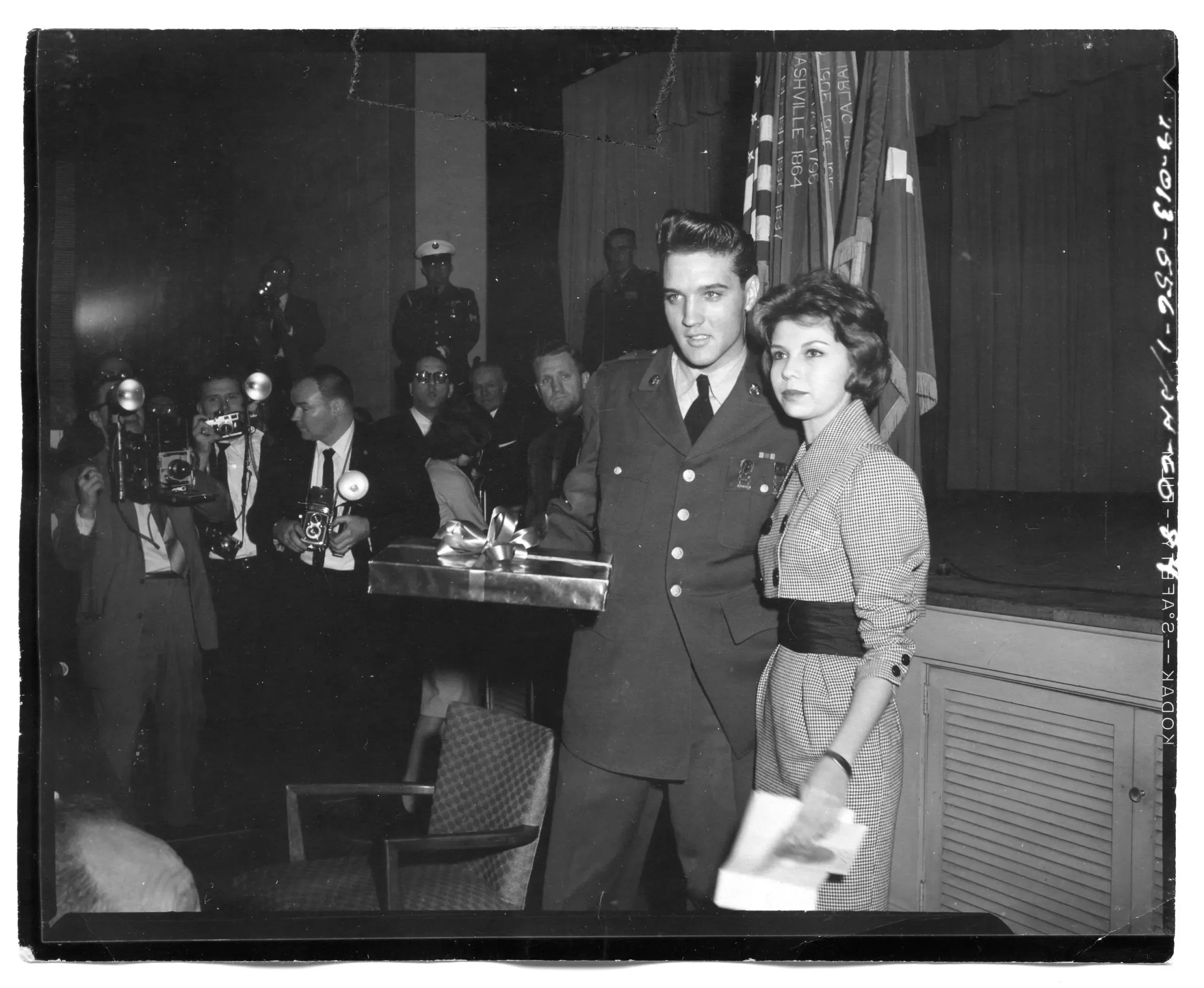 Sgt Elvis Presley, rock & roll singer, TV & Movies, receives a gift from Miss Nancy Sinatra, daughter of Frank Sinatra, singer and movie actor, at a press conference held by Sgt Presley in Service Club #1. Sgt Presley was separated from the US Army today here at Fort Dix. 5 March 1960.