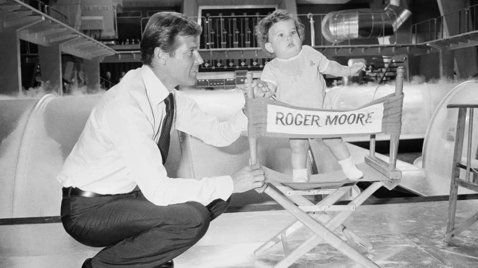 Sir Roger Moore on the Bond film set of The Man With The Golden Gun, holding his young son Christian's hand.