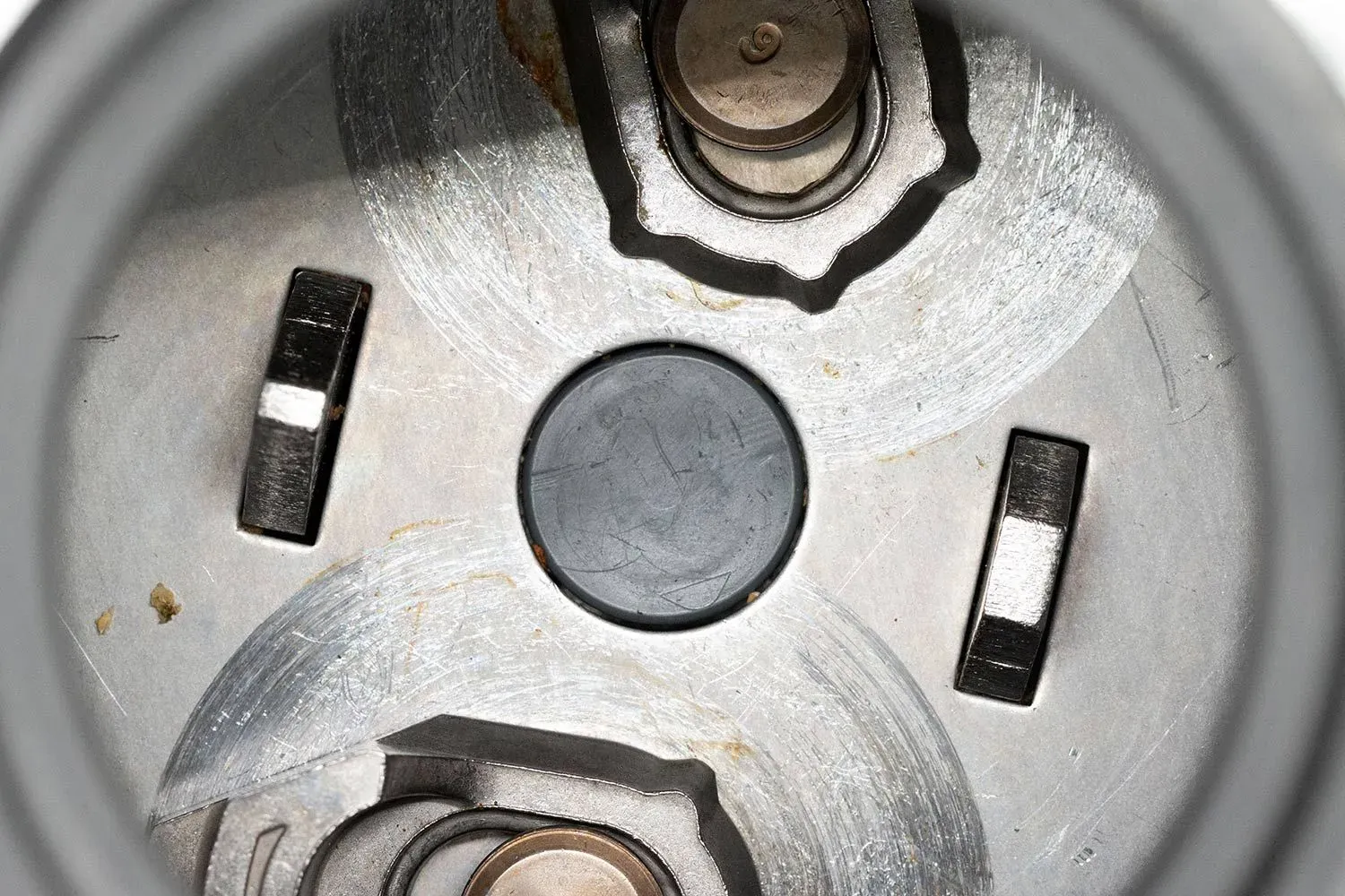 Top view through collar of Evolution Excel 1-hp garbage disposal into chamber, highlighting parts of Tri-Action Lug system by InSinkErator, partially showing details of flywheel.
