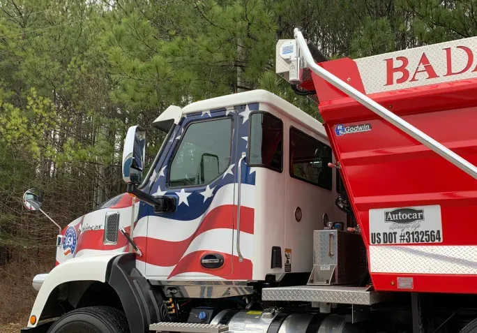 The Autocar DC features a wrap-around windshield and rear-quarter windows for enhanced visibility.