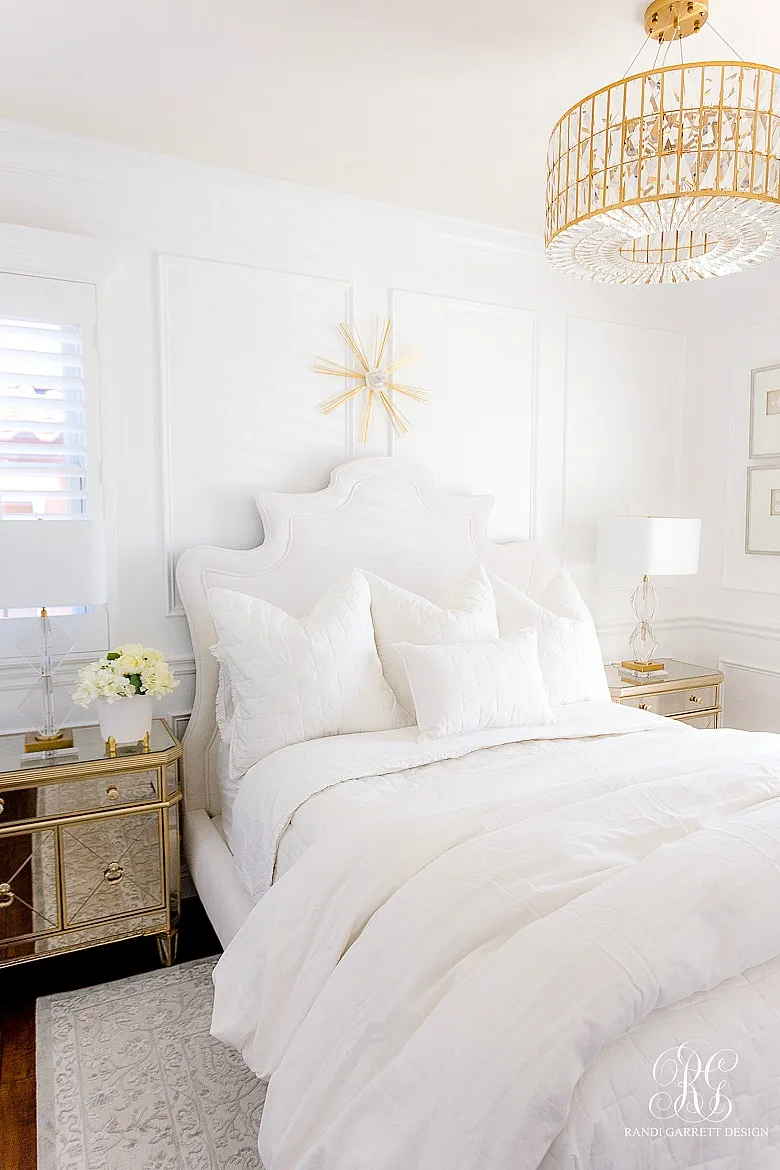 A beautifully made bed with white coverlets and pillows.