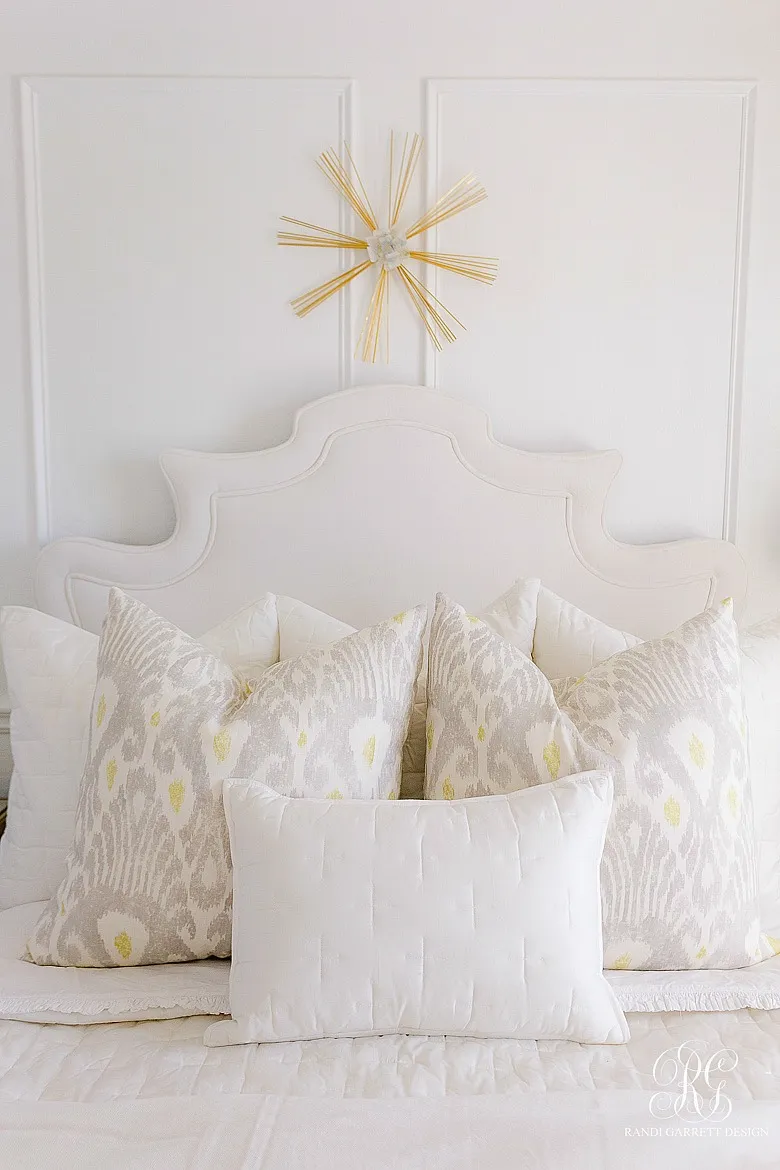 A bed styled with Euro pillows, including two with a block print pattern.
