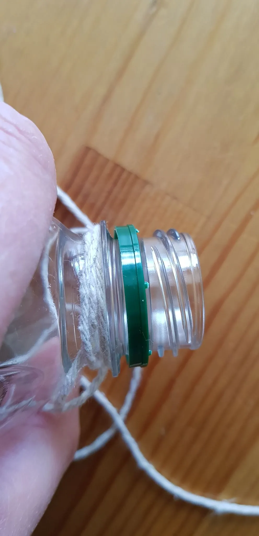 A close-up of the bottle top with the strings tied securely around the rim, preparing for play.