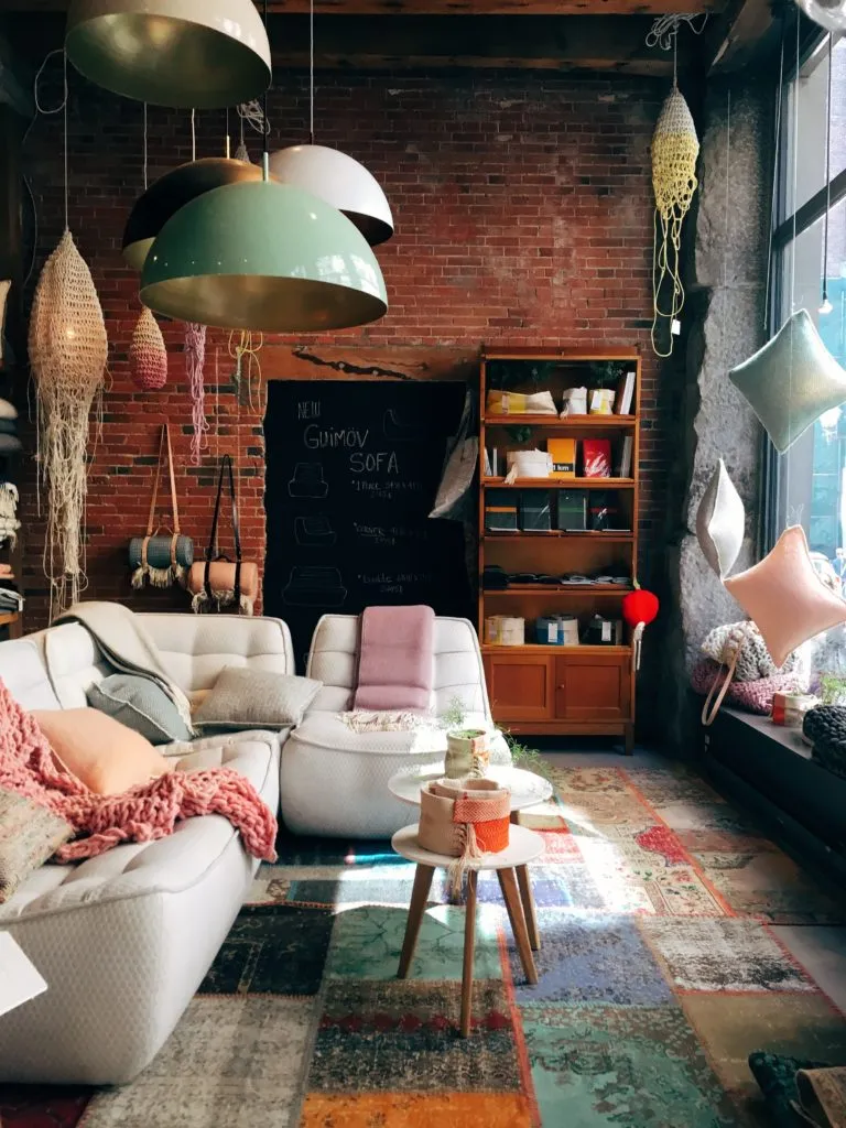 A person is sitting on a sofa in a modern living room, looking at a laptop.