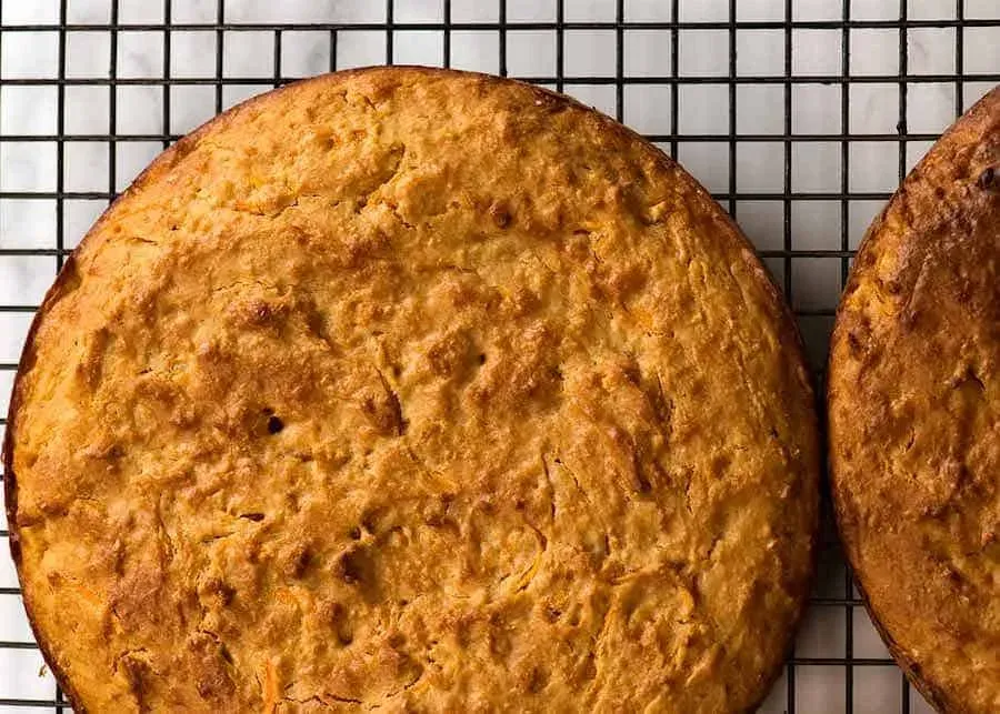 Two freshly baked dog cake layers cooling on a wire rack, golden brown and perfectly risen