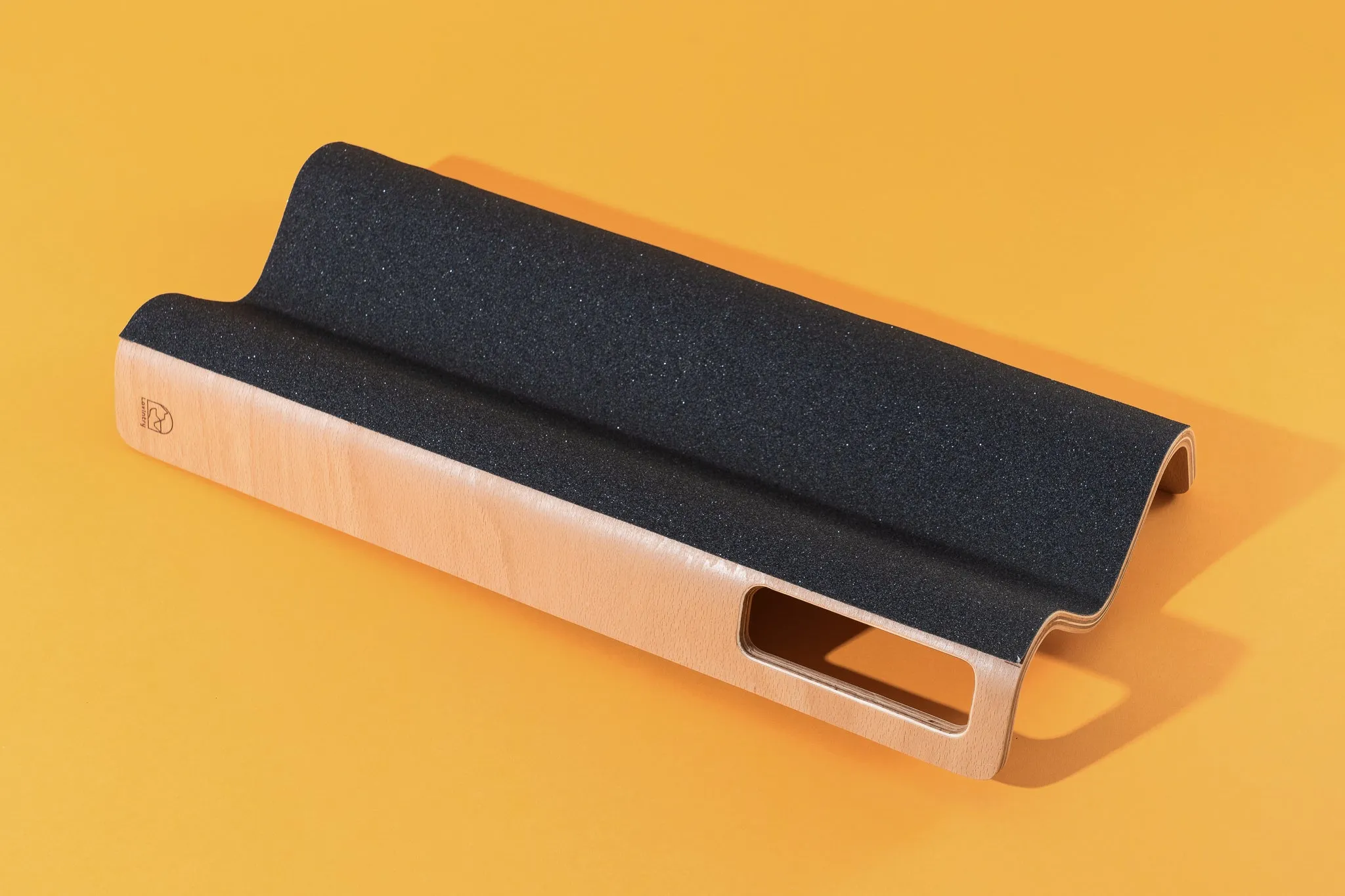 A LovIntry M-Shaped Dog Scratch Pad for Nails resting on a yellow background.